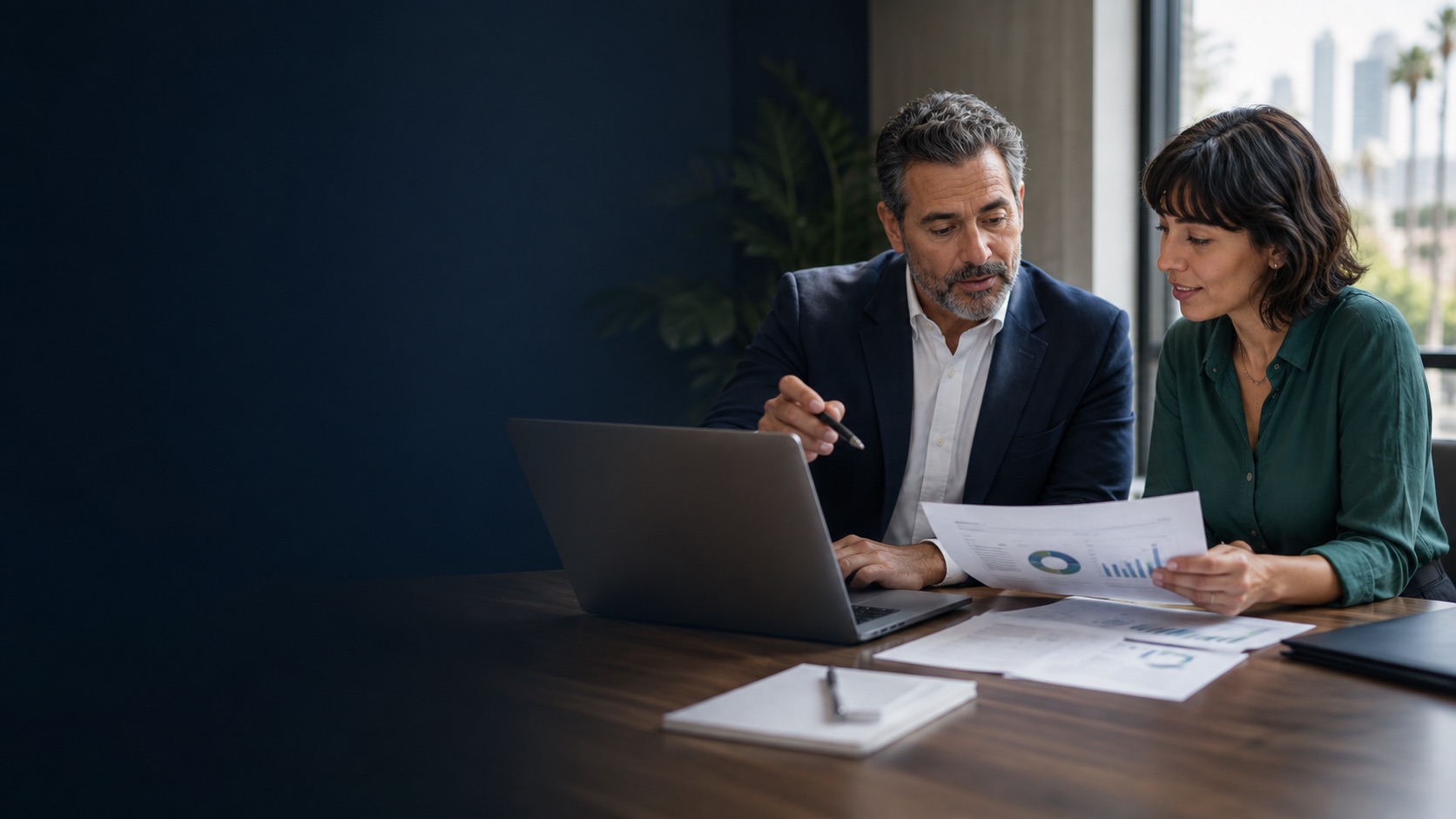 Los Angeles business owner reviewing financial reports with an accounting and controller-services professional
