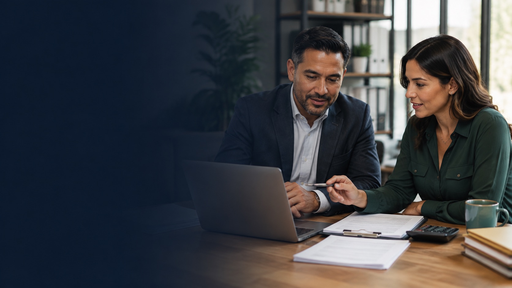 Small-business owner reviewing payroll records with an experienced payroll support professional